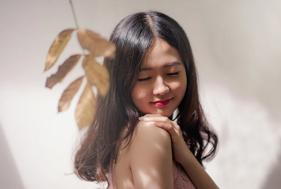 smiling woman touching her shoulder